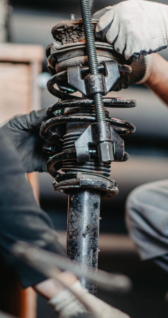 Gloved hands pull out the steering column during suspension and steering repair services in Pompano Beach