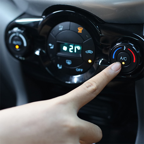Finger presses a/c knob after air conditioning repair in Pompano Beach