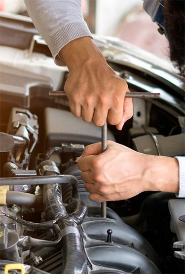 Hands of a mechanic fixing a car in need of tire and auto repair in Pompano Beach.