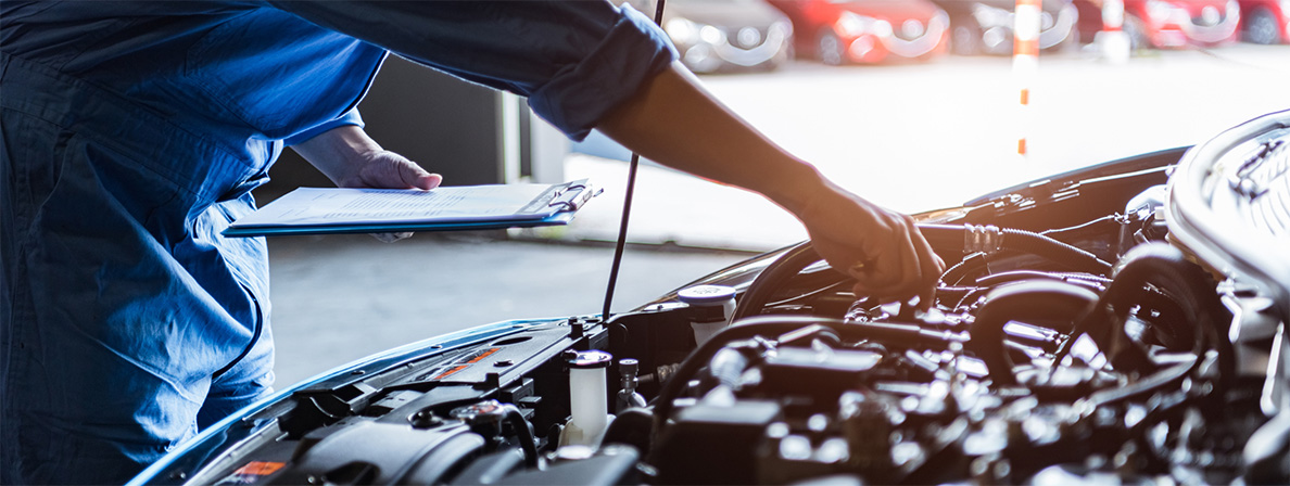 A mechanic with a clipboard checks off items during auto maintenance