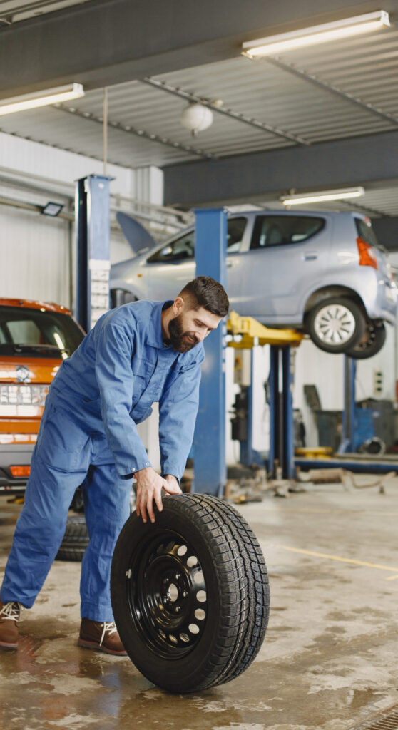 Mechanic rolls a new tire out for tire installation service in Pompano Beach