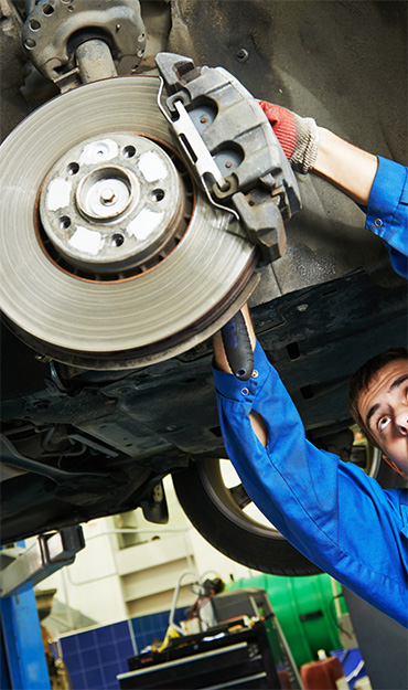 A mechanic adjusts a brake pad during brake repair services in Pompano Beach
